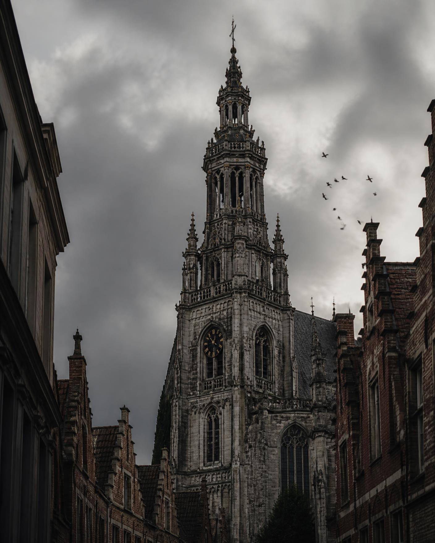 Barokke toren van de Sint-Pauluskerk tegen een grijze lucht