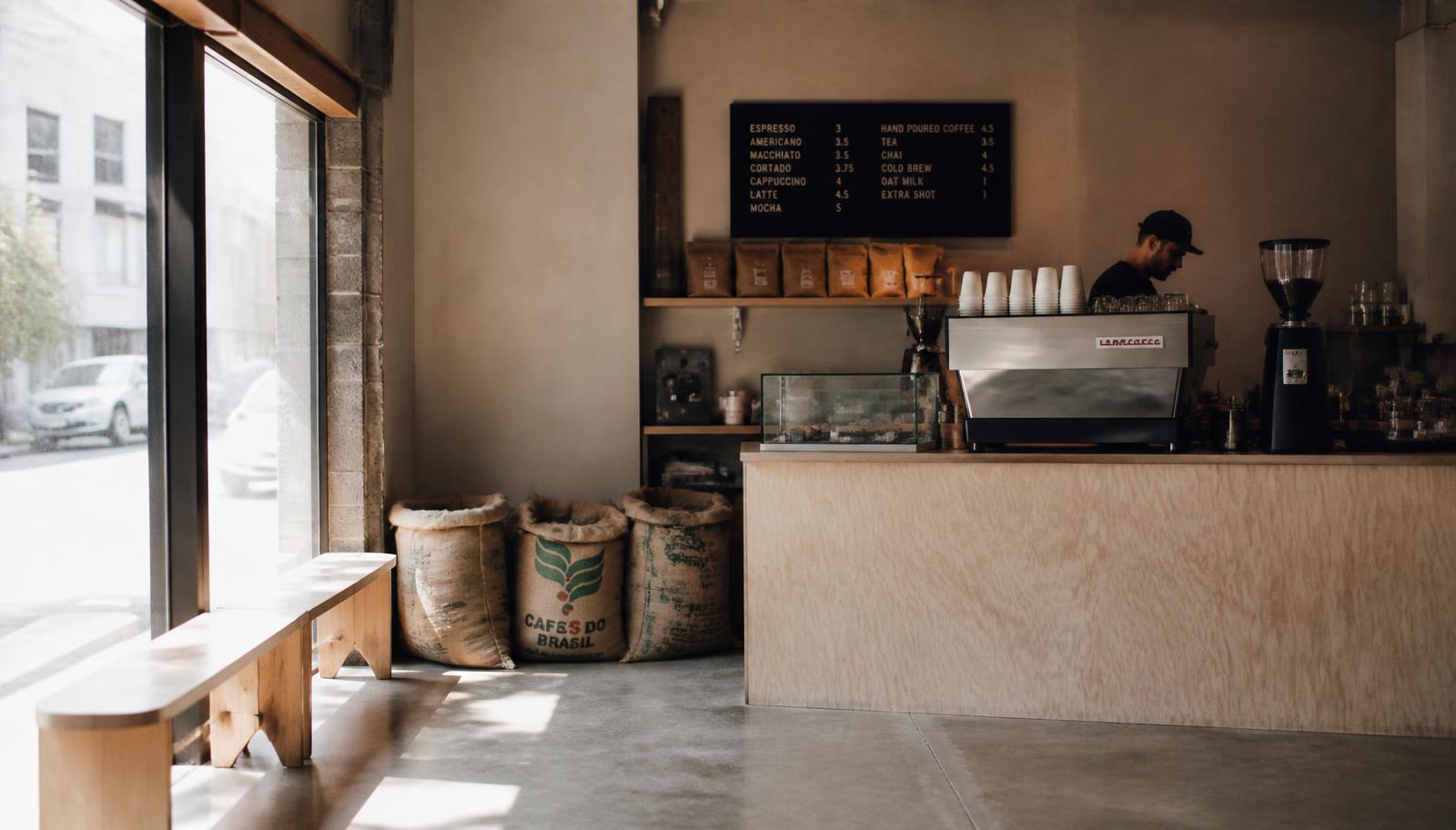 Ruw afgewerkte koffiebar met espressomachine en koffiezakken